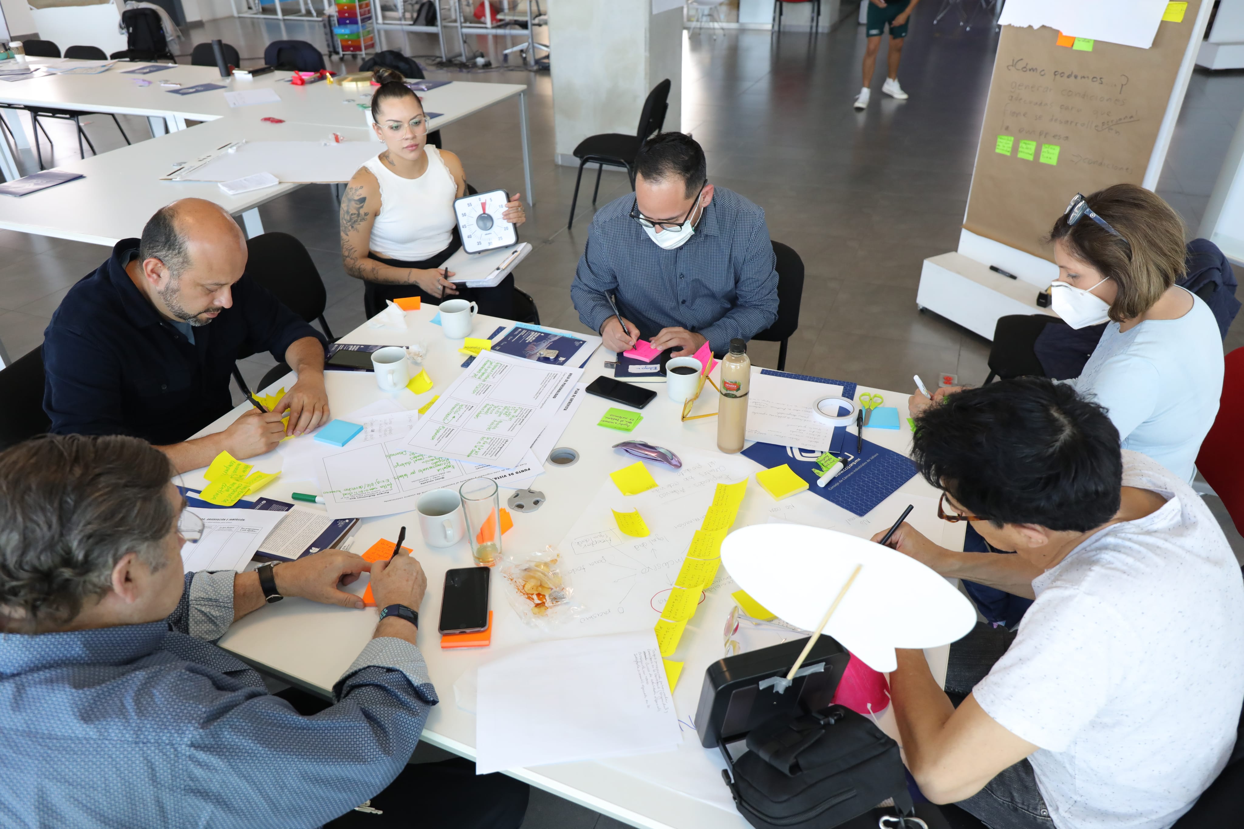 Equipo colaborando alrededor de una mesa